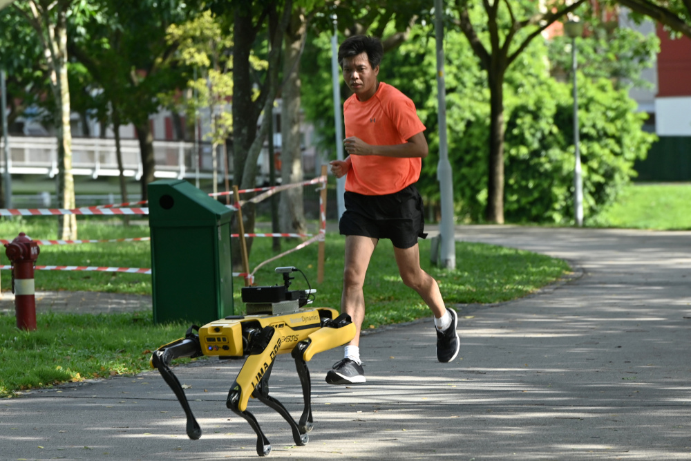 In this file photo taken May 8, 2020, a man jogs past a four-legged robot called Spot, which broadcasts a recorded message reminding people to observe safe distancing, during its two-week trial at the Bishan-Ang Moh Kio Park in Singapore. u00e2u20acu201d AFP pic 
