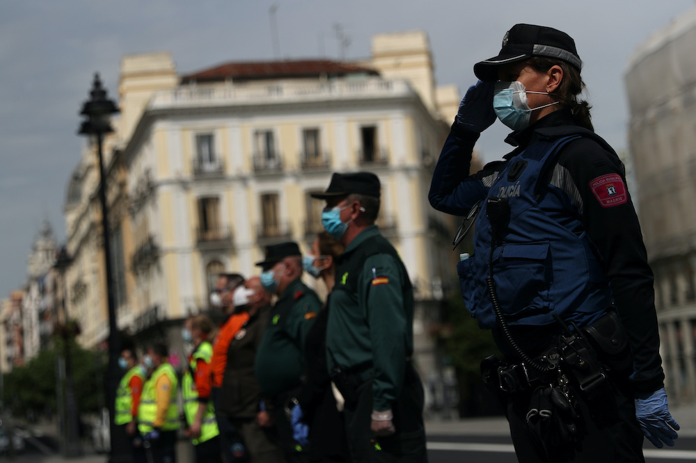 Spanish Civil Guards and Madrid police officers stand still during a minute of silence for victims of the coronavirus disease, at Puerta del Sol square in Madrid, Spain, May 7, 2020. u00e2u20acu201d Reuters picnn
