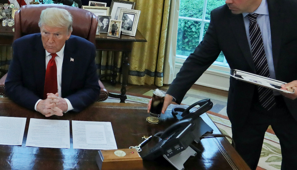 An unidentified valet places a glass of soda on US President Donald Trumpu00e2u20acu2122s desk as he engages in an interview with Reuters during the coronavirus disease response at the White House in Washington, UA, April 29, 2020. u00e2u20acu201d Reuters picnn