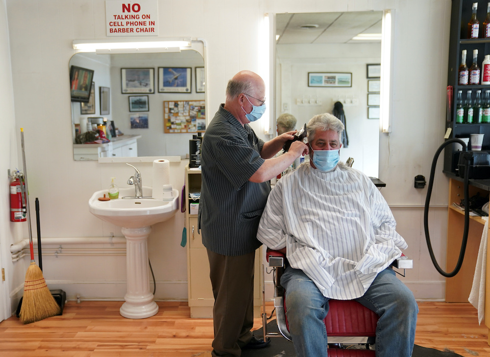 Wayne Bunting, who has run his barbershop for 48-years, gives a haircut on his first day back in business after coronavirus disease restrictions were relaxed in Dagsboro, Delaware, US, May 8, 2020. — Reuters pic