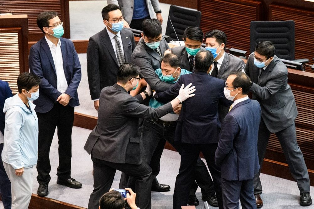 Pro-democracy lawmaker Wu Chi-wai (centre, green shirt) is escorted by security out of the Legislative Council after pro-democracy lawmakers disrupted a House Committee meeting concerning the second reading of a national anthem bill in the chamber in Hong