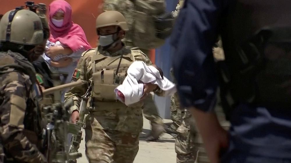 Afghan security personnel evacuate a baby from a hospital that was attacked in Kabul, Afghanistan May 12, 2020. u00e2u20acu201d Reuters video image