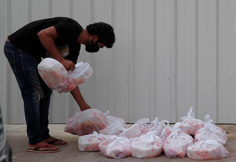 A migrant worker living in a construction site collects meals donated by charities for their Eid-al-Fitr celebrations amid the Covid-19 outbreak in Singapore May 24, 2020. u00e2u20acu201d Reuters pic