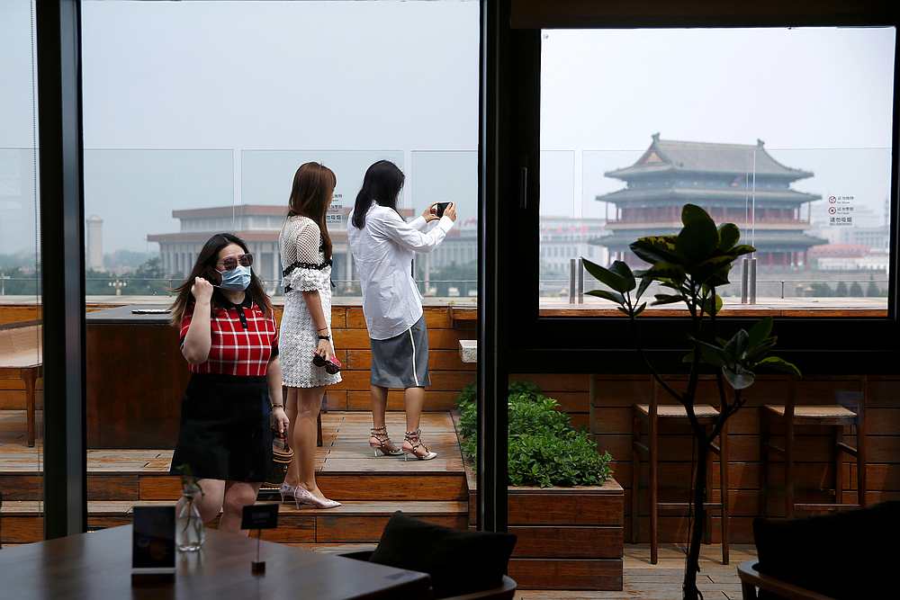 Customers wearing face masks take photos on a rooftop of a restaurant near Qianmen street in Beijing during Labour Day holiday in China May 3, 2020. u00e2u20acu201d Reuters pic