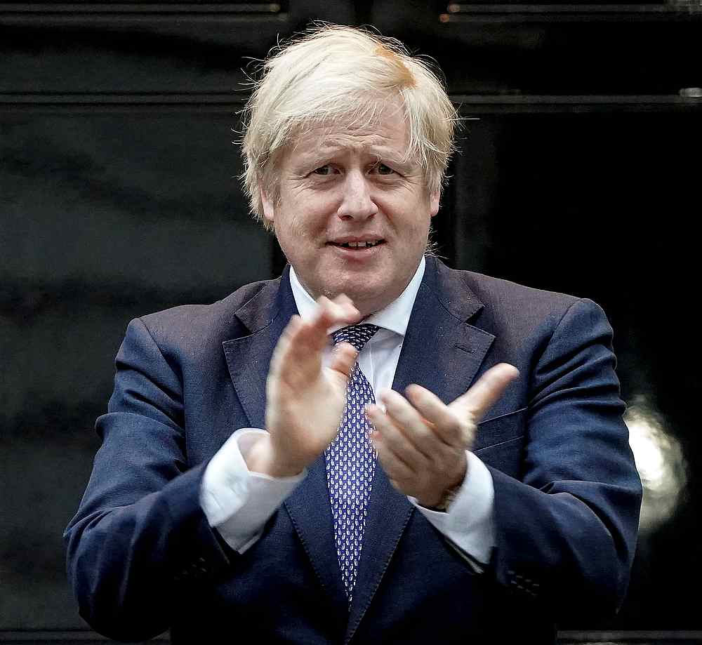 Britain's Prime Minister Boris Johnson takes part in a 'Clap for Carers' campaign at 10 Downing Street in London April 30, 2020. u00e2u20acu201d No 10 Downing Street handout via Reuters