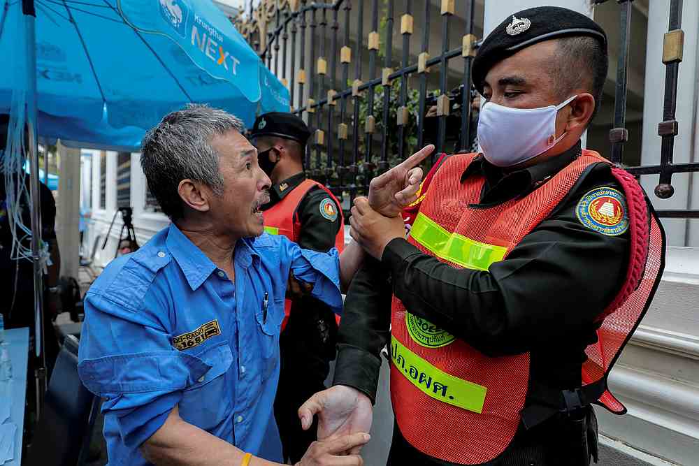 A taxi driver who has been affected by the government's anti-Covid-19 measures confronts a security guard as he complains outside the Finance Ministry in Bangkok, Thailand April 30, 2020. u00e2u20acu201d Reuters pic