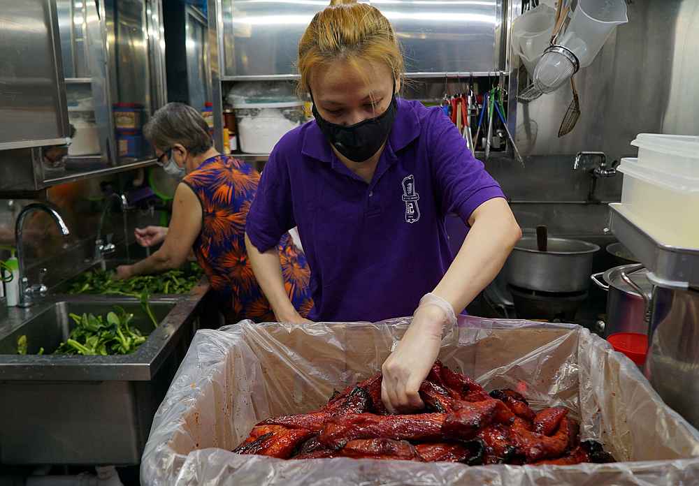Hawker Kristen Choong wears a protective mask as she prepares ingredients with her mother Lai Yau Kiew at their Hong Lim Hawker Centre stall, in Singapore May 10, 2020. u00e2u20acu201d Reuters pic