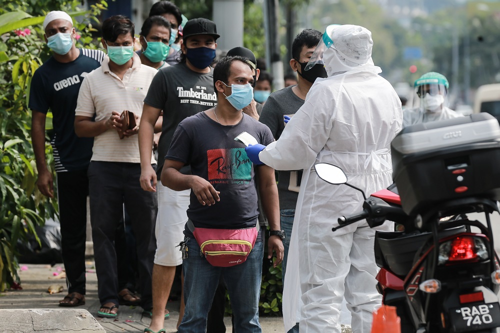 Health personnel assisting foreign workers during a Covid-19 screening in Kuala Lumpur May 8, 2020. ― Picture by Ahmad Zamzahuri