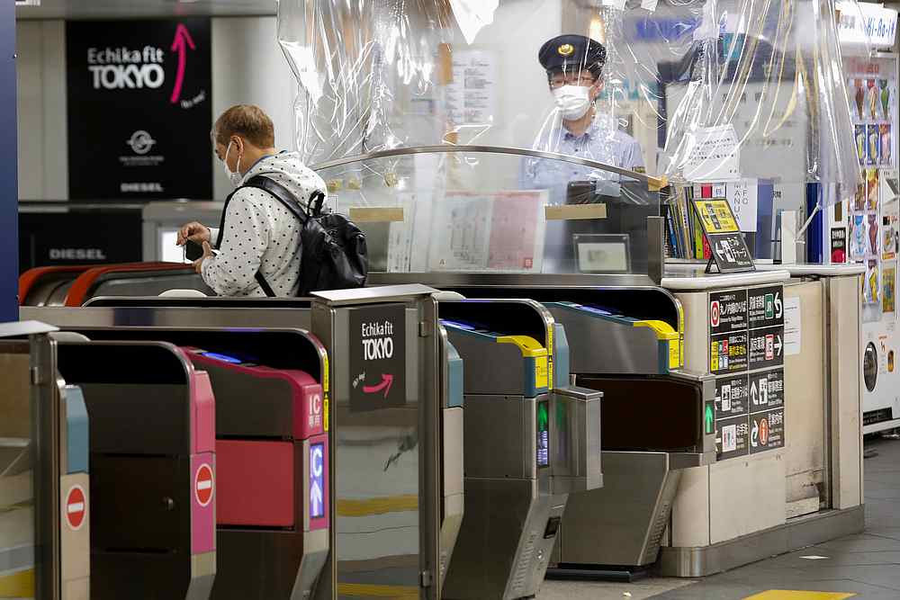 A staff member of the subway station, wearing a face mask, works behind a plastics curtain due to the outbreak of Covid-19, in Tokyo, Japan May 21, 2020. u00e2u20acu201d Reuters pic