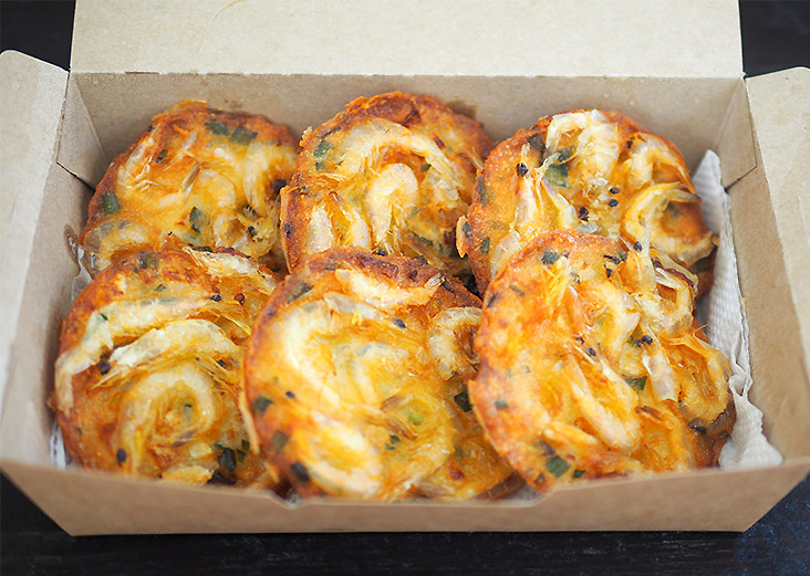 Each piece of 'cucur udang' is perfectly fried with a ring of small, white prawns.