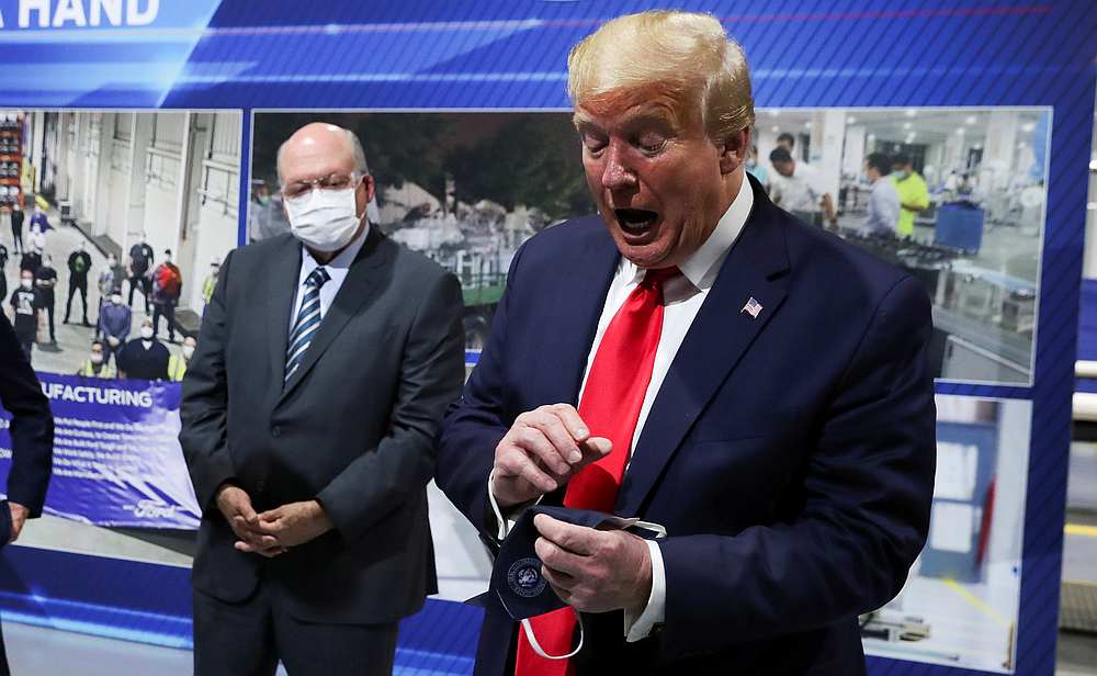 US President Donald Trump holds a protective face mask with a presidential seal on it that he said he had been wearing earlier in Ypsilanti, Michigan May 21, 2020. u00e2u20acu201d Reuters pic