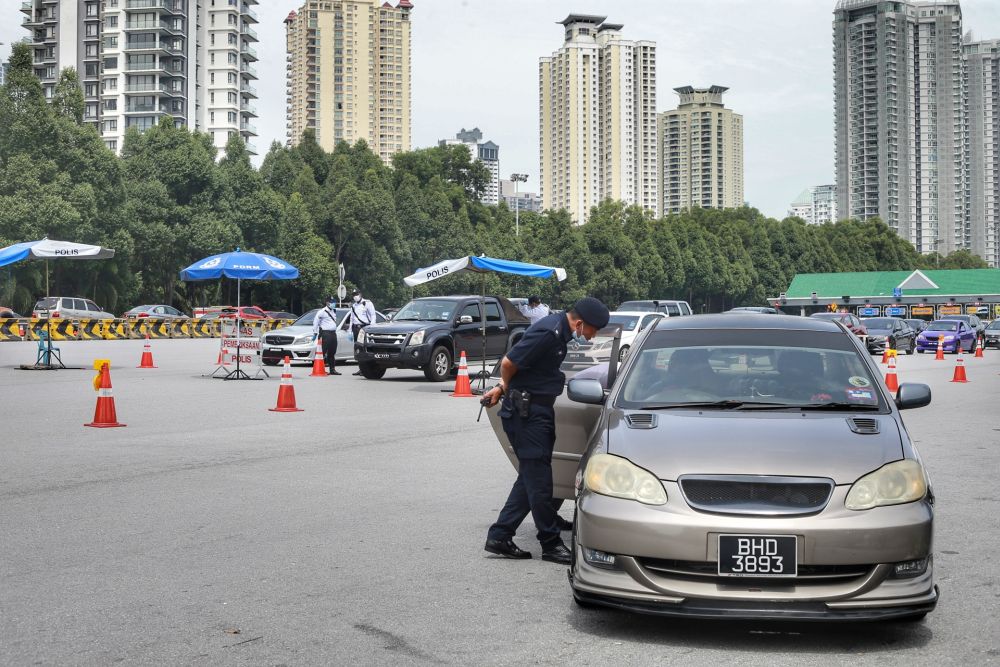 Police personnel conduct checks on vehicles at the Duta toll exit in Kuala Lumpur May 27, 2020. u00e2u20acu201d Picture by Ahmad Zamzahuri
