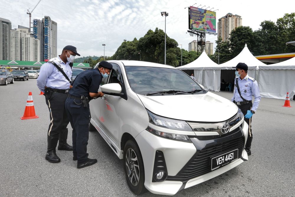 Police personnel conduct checks on vehicles at the Duta toll exit in Kuala Lumpur May 27, 2020. u00e2u20acu201d Picture by Ahmad Zamzahuri