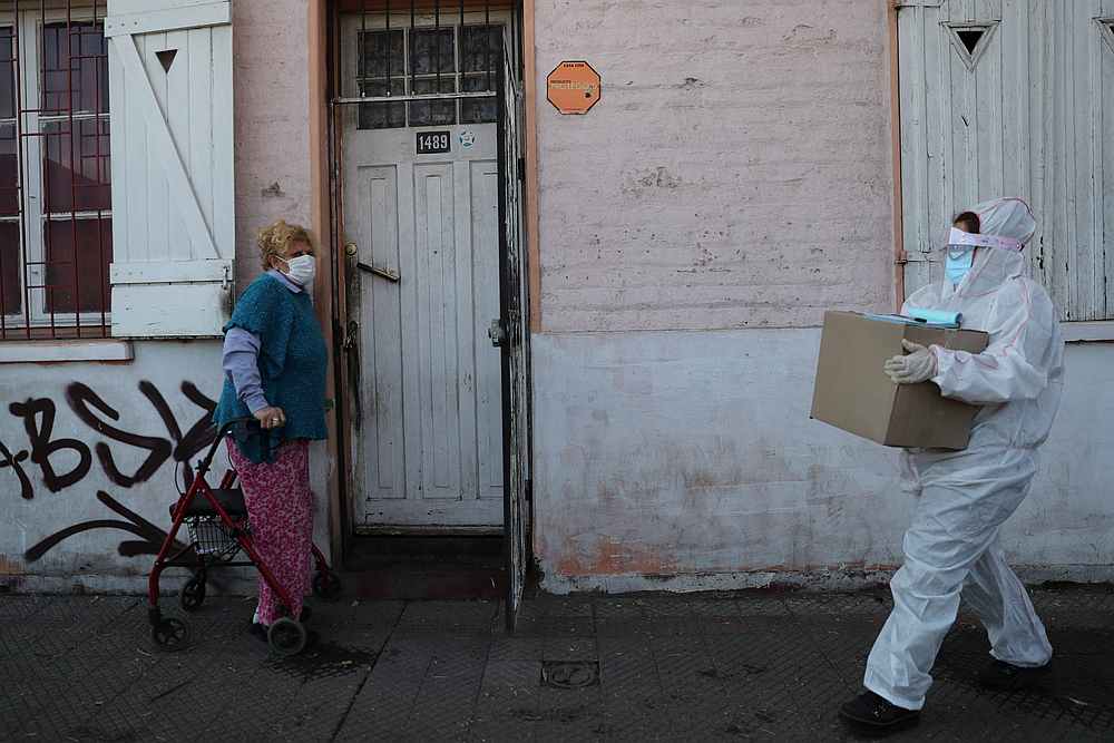 A woman prepares to receive a food parcel as part of a government food parcels programme distribution amid the spread of Covid-19 in Santiago, Chile May 22, 2020. u00e2u20acu201d Reuters pic