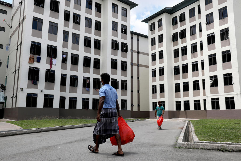 A foreign worker in Tampines Dormitory returns to his room with the catered lunch for his roommates. u00e2u20acu201d TODAY pic