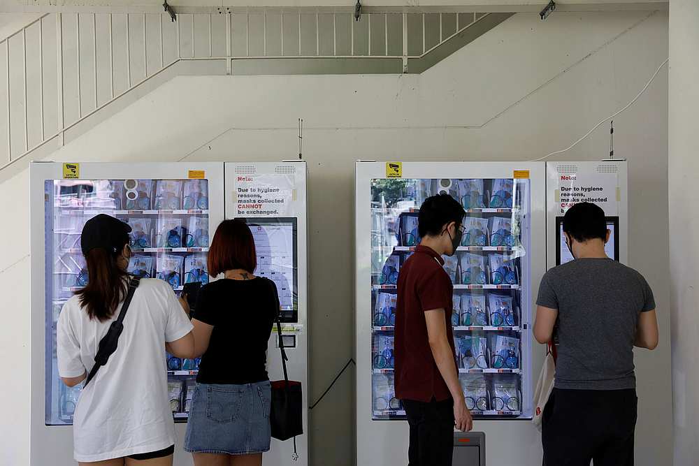 Residents collect free protective face masks issued by the government from vending machines set up in their housing estate, amid the Covid-19 outbreak in Singapore May 26, 2020. u00e2u20acu201d Reuters pic