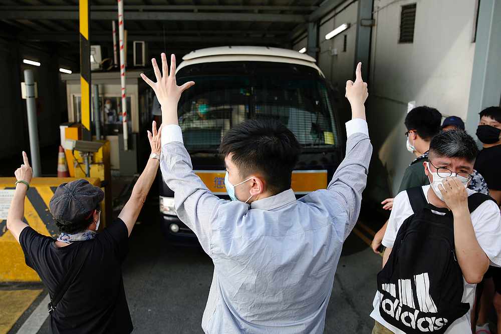Supporters raise their hands up symbolising of the 'Five demands, not one less' to bid farewell to a prison van after protester Sin Ka-ho has been sentenced four years for rioting, in Hong Kong May 15, 2020. u00e2u20acu201d Reuters pic