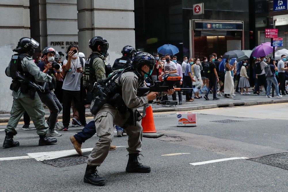 A riot police officer fires his weapon during a protest in Central Government Complex as a second reading of a controversial national anthem law takes place in Hong Kong May 27, 2020. u00e2u20acu201d Reuters picnn
