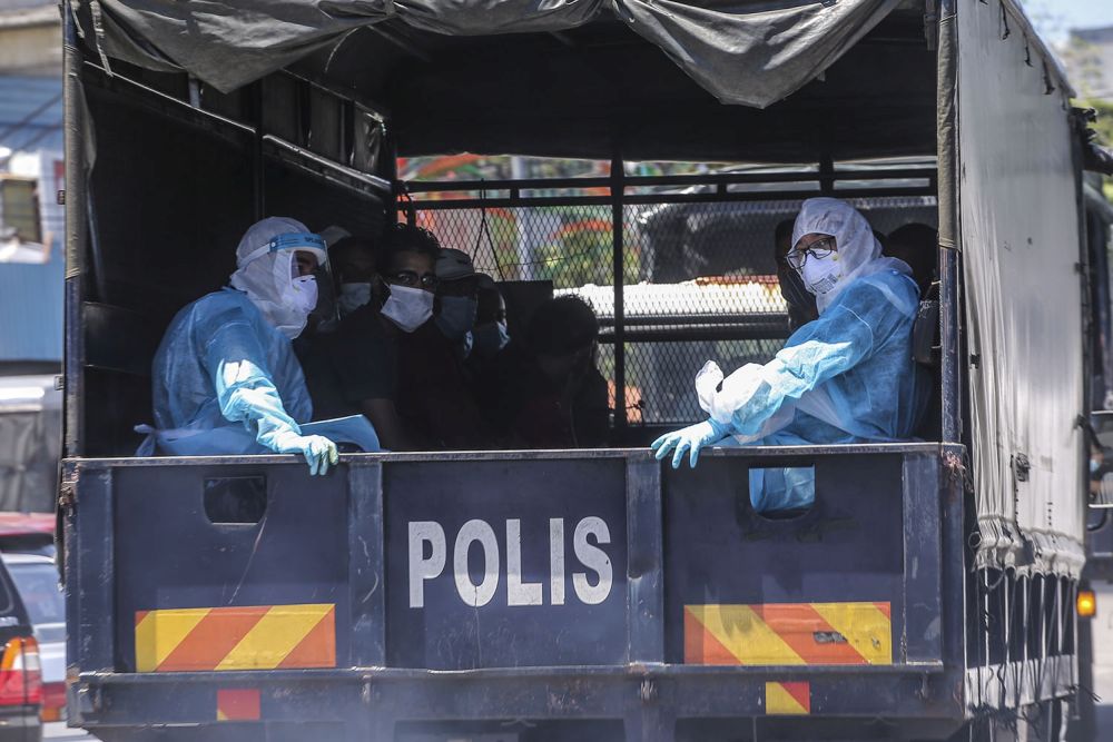 Illegal immigrants are pictured aboard a police truck following raids by the Immigration Department in Selayang Baru, Kuala Lumpur May 14, 2020. 