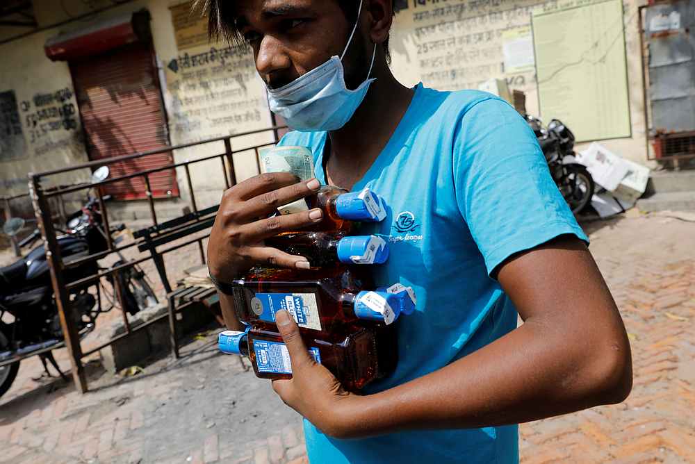 A man carries liquor bottles after buying them at a wine shop during an extended nationwide lockdown to slow the spread of Covid-19, in New Delhi, India, May 4, 2020. u00e2u20acu201d Reuters pic