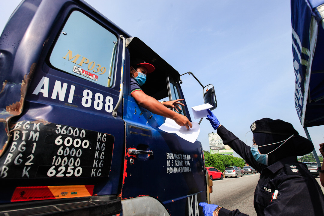 A police personnel inspects a driveru00e2u20acu2122s travel documents during a roadblock at the Jawi Toll Plaza in Penang May 19, 2020. u00e2u20acu201d Picture by Sayuti Zainudin