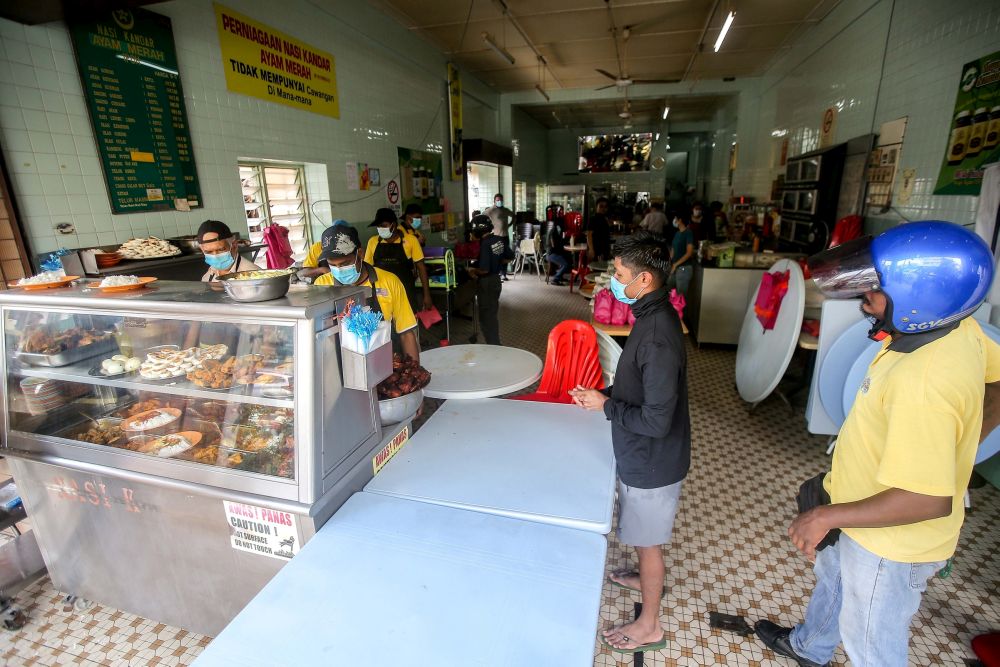 Members of the public observe social distancing guidelines while waiting to pack food at Nasi Kandar Ayam Merah in Ipoh May 4, 2020. u00e2u20acu201d Picture by Farhan Najib