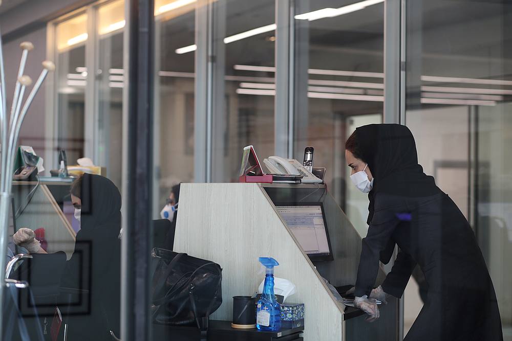 A stock market employee wearing a protective face mask and gloves looks at a screen displaying stock prices at Tehran Stock Exchange, Iran, May 12, 2020. u00e2u20acu201d Reuters pic