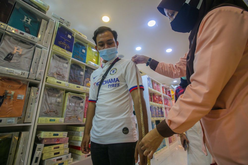 A customer has his measurements taken at the Jakel Ipoh textile shop May 13, 2020. u00e2u20acu201d Picture by Farhan Najib 