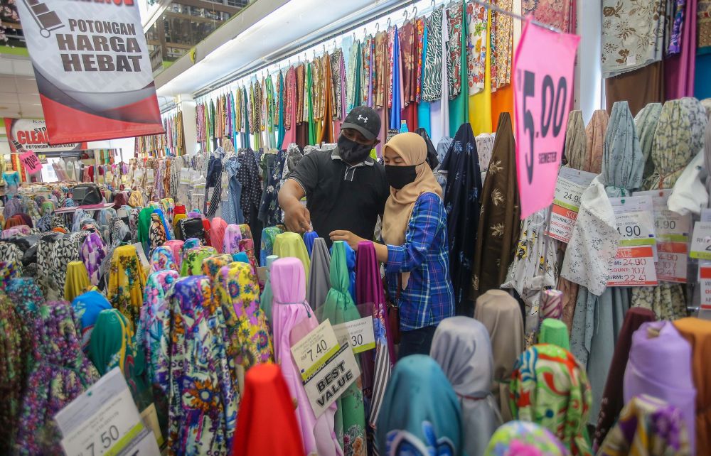 Customers browse through fabrics for their Hari Raya outfits at the Jakel Ipoh textile shop May 13, 2020. — Picture by Farhan Najib