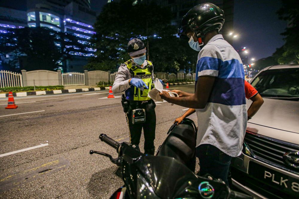 Traffic police personnel conduct checks on motorists during a roadblock on Jalan Raja Laut in Kuala Lumpur May 30, 2020. u00e2u20acu201d Picture by Hari Anggara