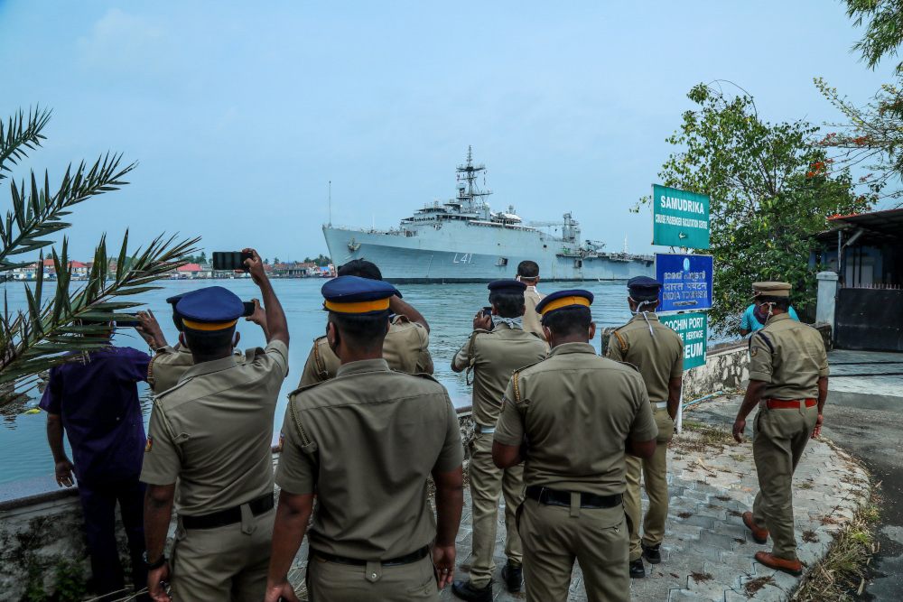 Kerala police personnel watch and take photos as the u00e2u20acu02dcINS Jalashwau00e2u20acu2122 ship enters the Cochin port carrying Indian citizens who were stranded in Maldives due to the Covid-19, in Kochi in the south Indian state of Kerala May 10, 2020. u00e2u20acu201d AFP pic 