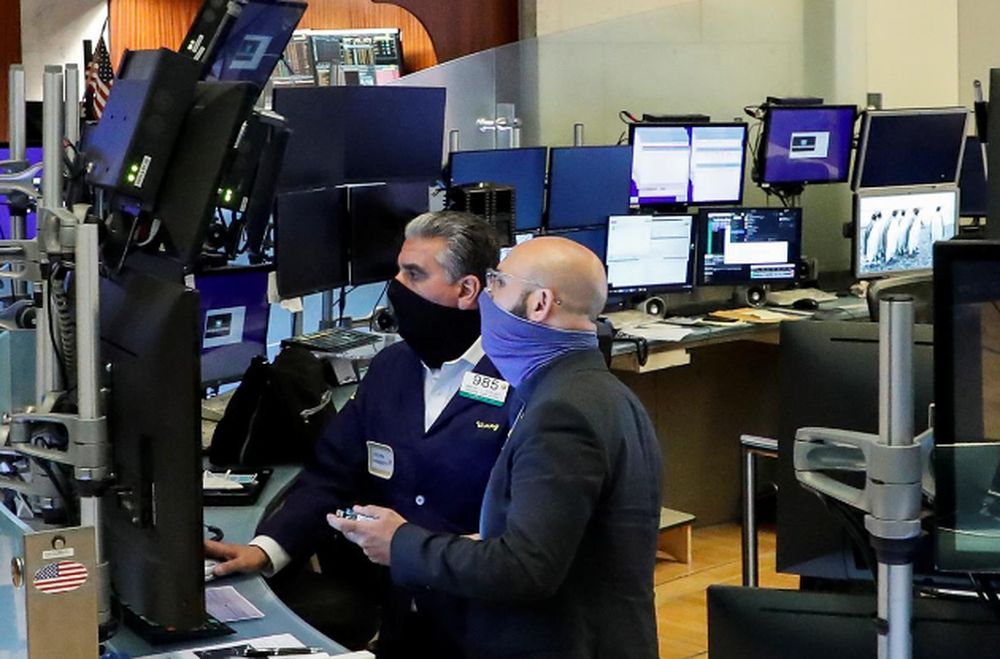 Traders wearing masks work, on the first day of in person trading since the closure during the outbreak of the coronavirus disease (Covid-19) on the floor at the New York Stock Exchange (NYSE) in New York, US, May 26, 2020. u00e2u20acu201d Reuters pic