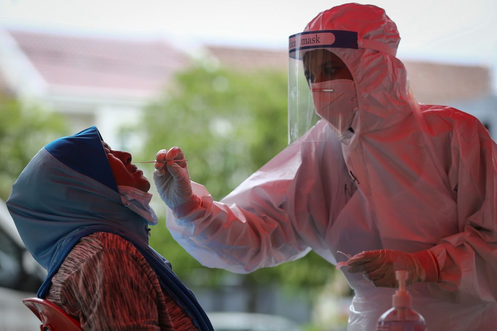 A Mercy Malaysia volunteer screens those from marginalised communities for Covid-19 at the Qatar Fund For Development humanitarian clinic at Ampang, Kuala Lumpur May 13, 2020. u00e2u20acu201d Picture by Yusof Isa
