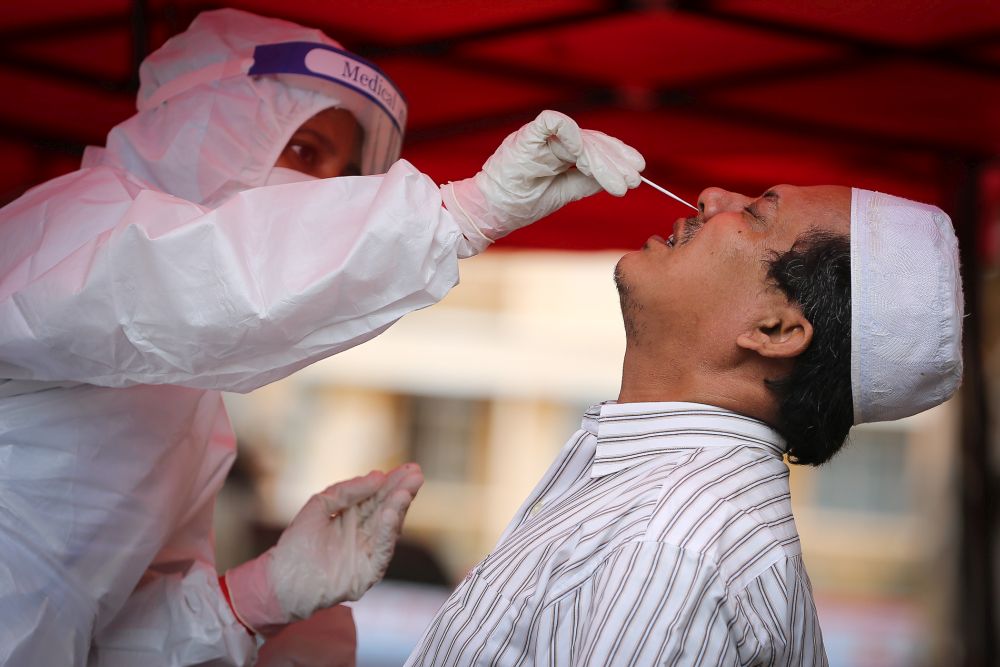 A Mercy Malaysia volunteer screens those from marginalised communities for Covid-19 at the Qatar Fund For Development humanitarian clinic at Ampang, Kuala Lumpur May 13, 2020. u00e2u20acu201d Picture by Yusof Isa