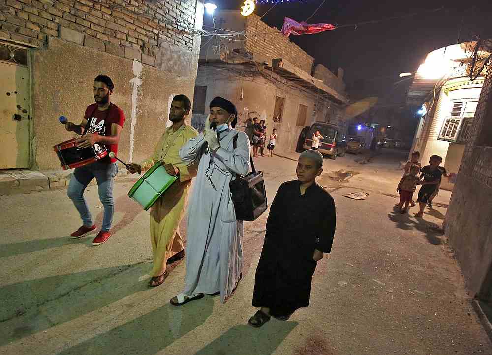 Sayyed Mozahem, the 'Musaharati' (second right), calls for Muslims to have their final meal before a new day of fasting begins with the sunrise, in a small neighbourhood of Baghdad May 7, 2020. u00e2u20acu201d AFP pic