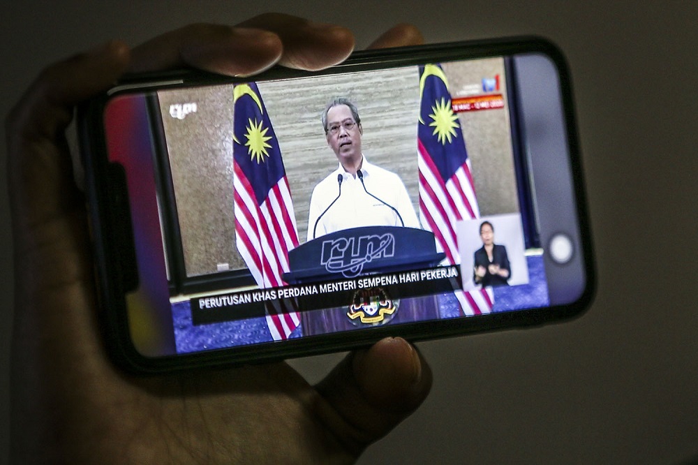 People watch the live telecast of Prime Minister Tan Sri Muhyiddin Yassin speaking about the fourth phase of the MCO in Kuala Lumpur May 1, 2020. u00e2u20acu2022 Picture by Hari Anggara