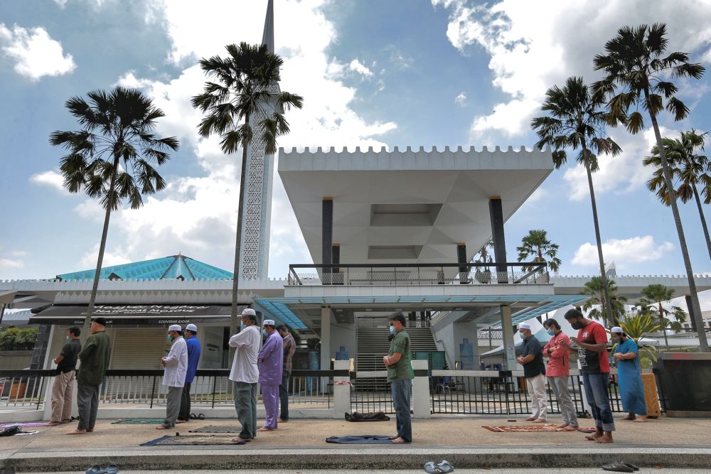 Muslims perform Friday prayers outside the National Mosque in Kuala Lumpur May 15, 2020. — Picture by Ahmad Zamzahuri