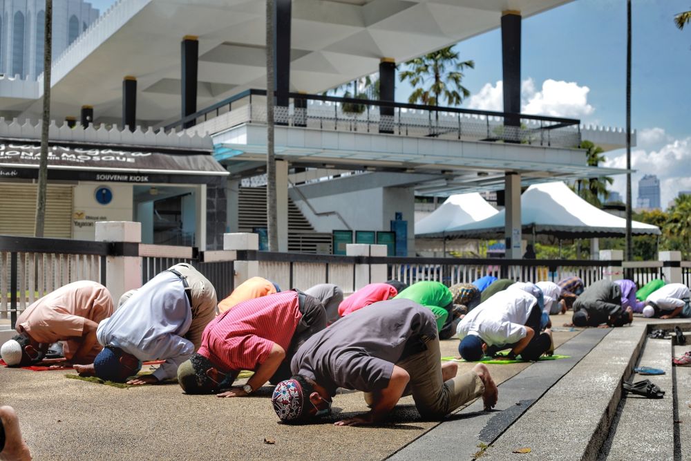 Muslims perform Friday prayers outside the National Mosque in Kuala Lumpur May 15, 2020. — Picture by Ahmad Zamzahuri