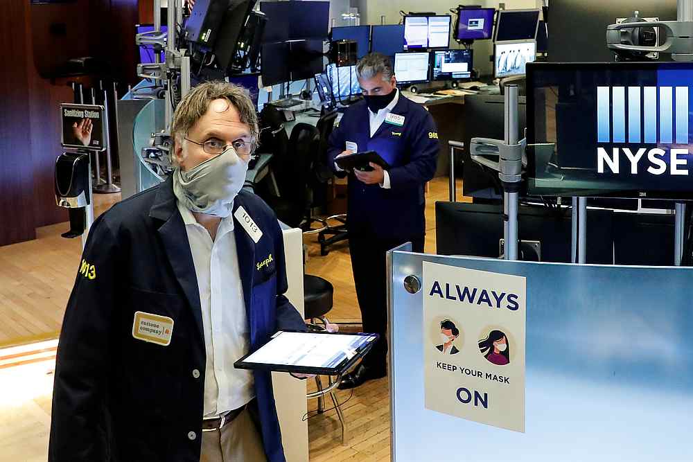 Traders wearing masks work, on the first day of in person trading since the closure during the outbreak of Covid-19 on the floor at the New York Stock Exchange May 26, 2020. u00e2u20acu201d Reuters pic