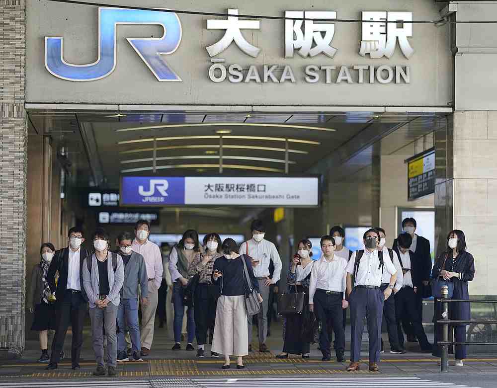 Commuters wearing protective masks head to work amid the Covid-19 outbreak in Osaka, Japan May 21, 2020. u00e2u20acu201d Kyodo pic via Reuters