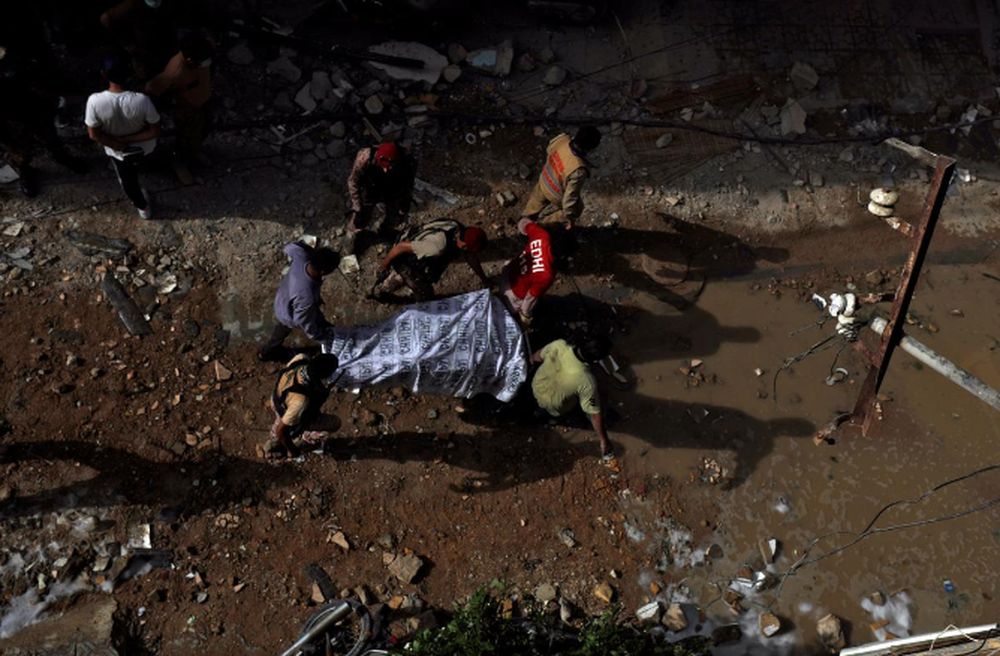 Rescue workers carry a victim at the site of a passenger plane crash in a residential area near an airport in Karachi, Pakistan May 22, 2020. u00e2u20acu201d Reuters pic