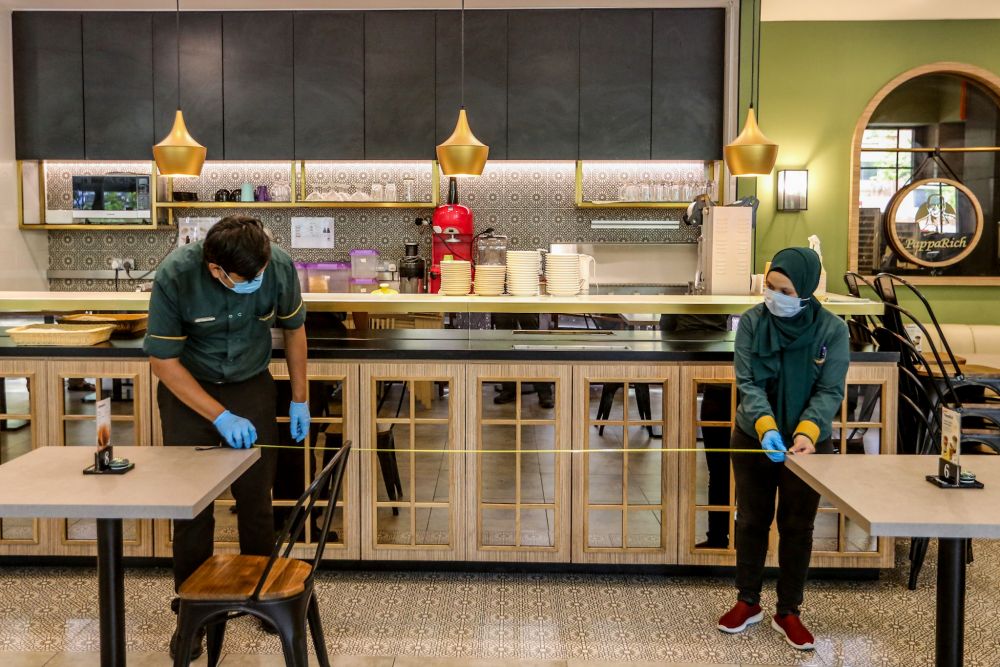 PappaRich staff arrange tables to comply with social distancing guidelines within its premises in Kuala Lumpur May 3, 2020. u00e2u20acu201d Picture by Firdaus Latif