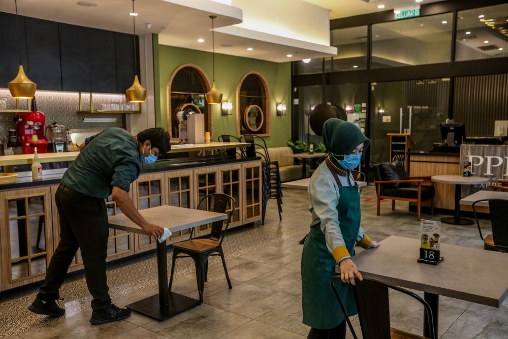 PappaRich staff carry out sanitising and cleaning work within the premises in Kuala Lumpur as eateries gets ready to resume dine-in services starting tomorrow. u00e2u20acu201d Picture by Firdaus Latif