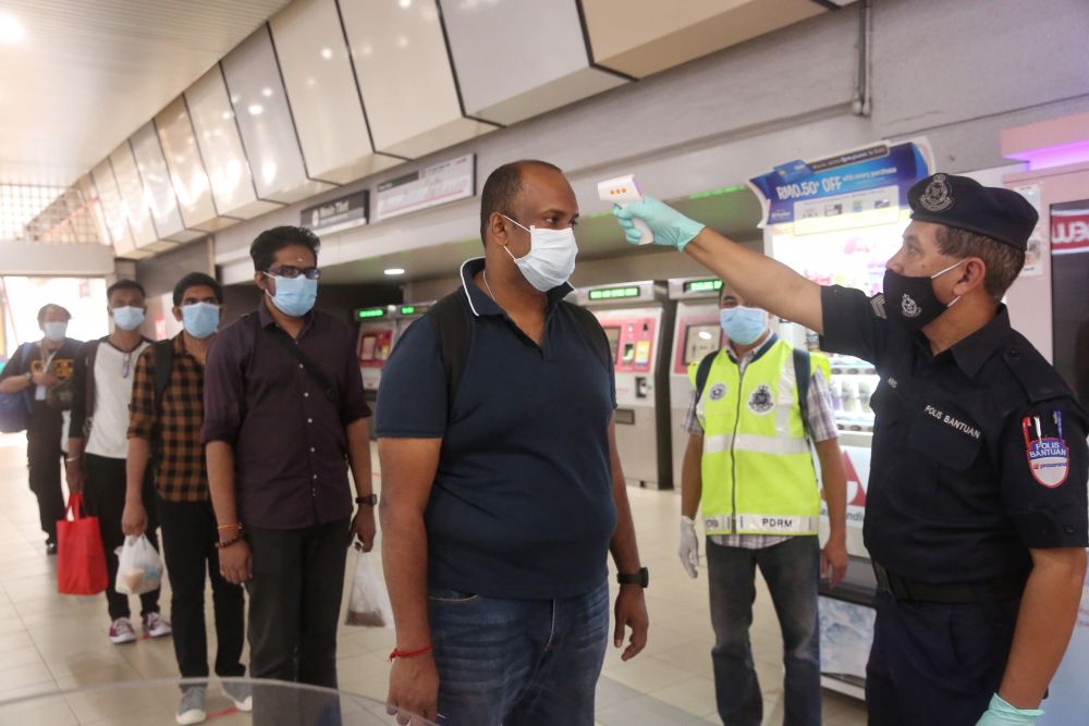 Commuters have their temperature checked at the Pasar Seni LRT station in Kuala Lumpur May 4, 2020. — Picture by Choo Choy May