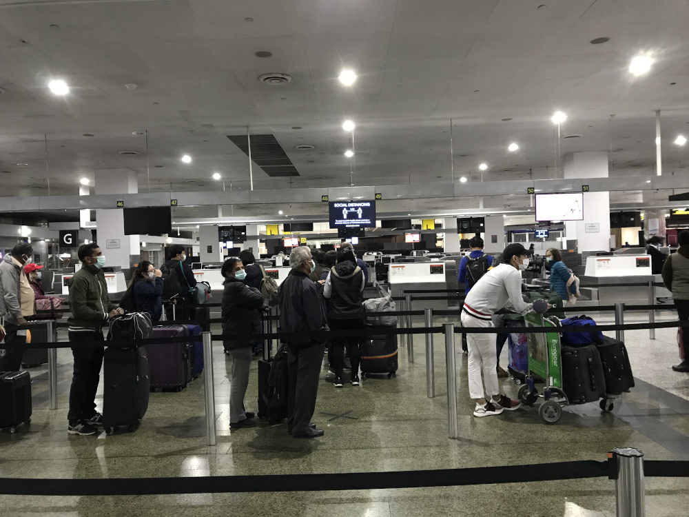 Passengers at Melbourne Airport observing social distancing while waiting to check-in for their flight home. u00e2u20acu201d Picture courtesy of Malaysia Airlines