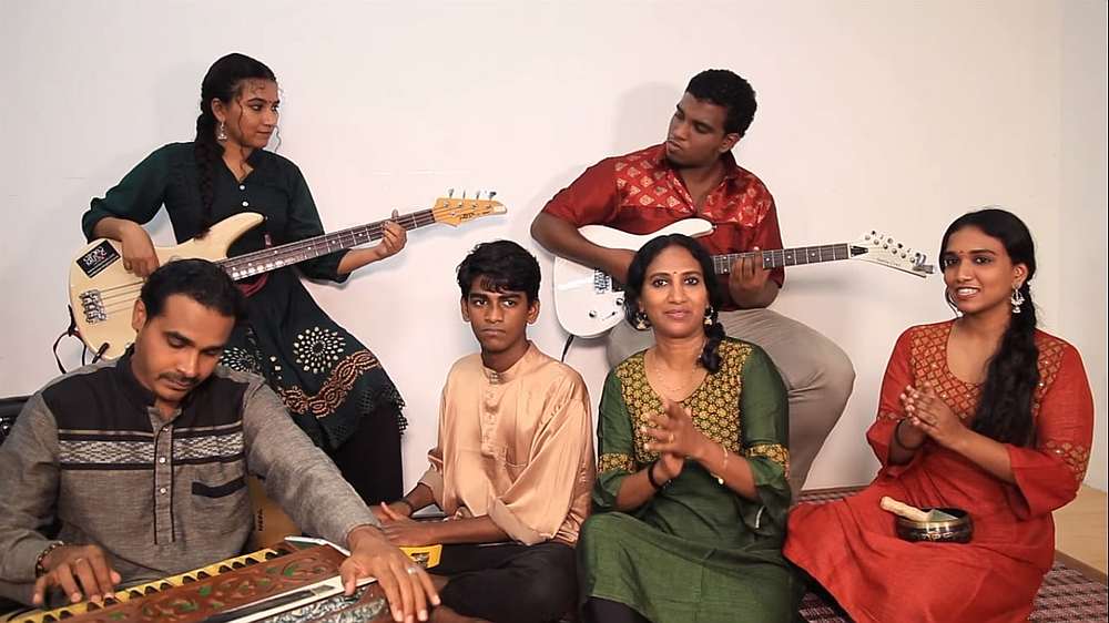 Savithri (sitting, in green) together with family members as they sing the Hari Raya song using a variety of musical instruments. u00e2u20acu201d Facebook/UniqueArtsCultureandHeritageMalaysia