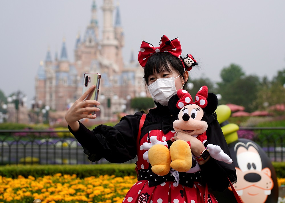 A visitor dressed as a Disney character takes a selfie while wearing a protective face mask at Shanghai Disney Resort as the Shanghai Disneyland theme park reopens, May 11, 2020. u00e2u20acu2022 Reuters pic 