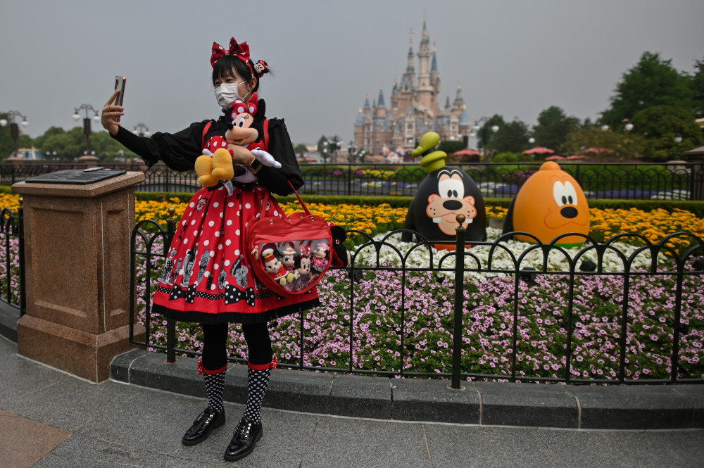A woman wearing a face mask takes a selfie while visiting the Disneyland amusement park in Shanghai May 11, 2020. u00e2u20acu201d AFP pic 