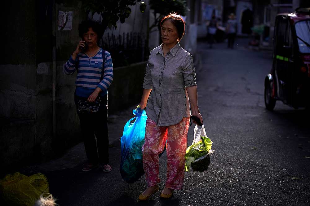 A woman carries vegetables at a residential community following an outbreak of Covid-19, in Shanghai, China May 12, 2020. u00e2u20acu201d Reuters pic