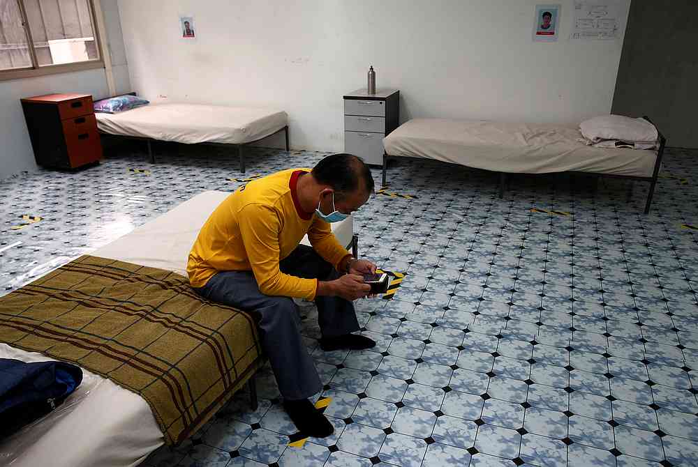A migrant worker sits on his bed in temporary living quarters for essential migrant workers at a train station construction site in Singapore May 5, 2020. u00e2u20acu201d Reuters pic